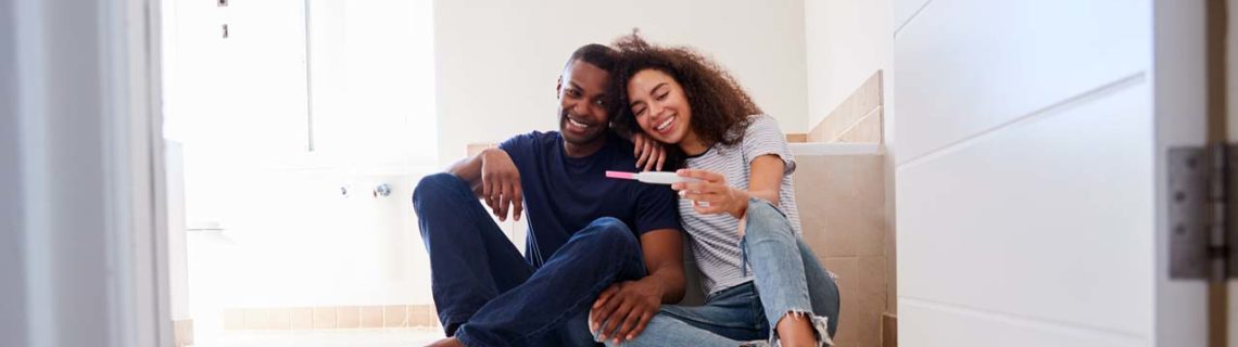 Para mujeres fertilidad pareja sentada en el suelo prueba de embarazo